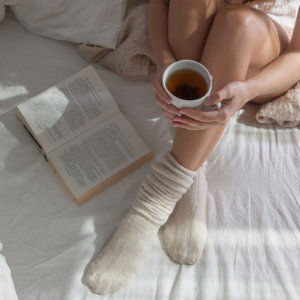 Frau liest Buch im Bett